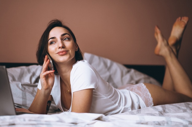 Femme au lit avec un téléphone