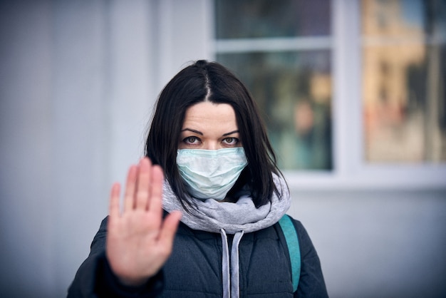 Femme au masque dans la rue en raison de l'épidémie de coronavirus en ville.