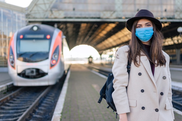 Femme au masque de protection à la gare.