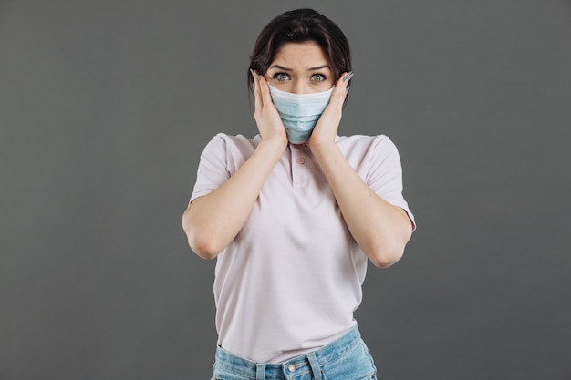 Femme au masque de protection médicale montre la peur du coronavirus