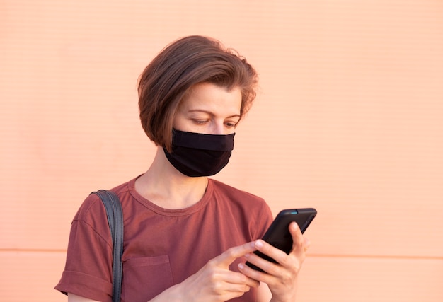 La femme au masque utilise un téléphone portable