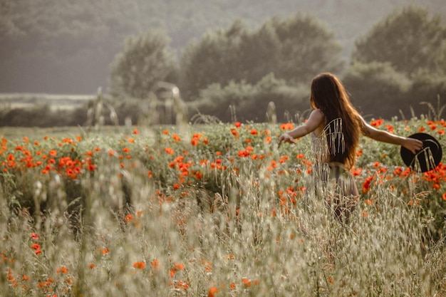 Une femme au milieu des plantes à fleurs sur le champ