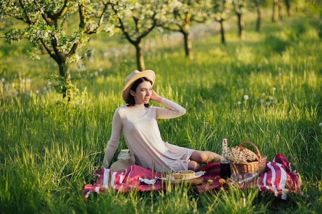 femme au pique-nique au printemps jardin fleuri au printemps ensoleillé