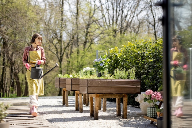 Femme au potager à la maison dans l'arrière-cour de sa maison