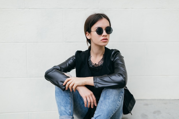 Femme au repos près du mur blanc