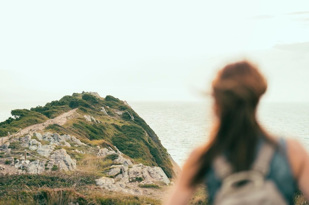 Femme au sommet d'une falaise regardant l'horizon