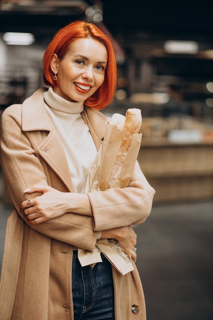 Femme au supermarché achetant du pain frais