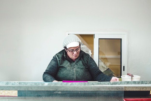 Femme au travail au travail devant un tapis roulant