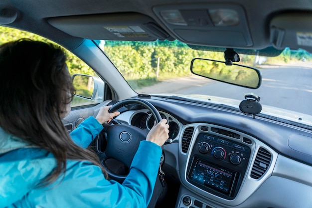 une femme au volant d'une voiture, une jeune femme au volant de sa voiture, une vue intérieure.