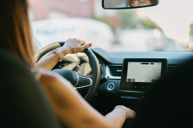 Femme au volant d'une voiture vue de derrière