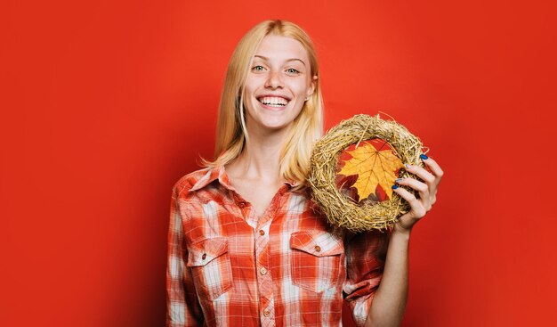 Femme d'automne en chemise à carreaux avec décoration faite à la main de couronne automnale décorative pour les vacances