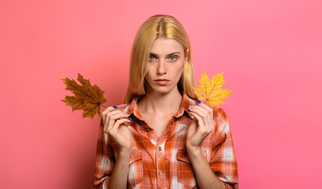 Femme d'automne en chemise à carreaux avec des feuilles d'érable jaunes mode d'automne fille d'automne sérieuse avec de l'or