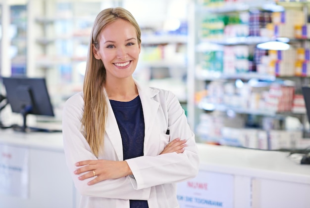 Femme aux bras croisés et portrait avec sourire à la pharmacie pour le service à la clientèle médicaments et ordonnances Pharmacien heureux et travailleur médical au dispensaire pour l'approvisionnement en soins de santé ou les produits pharmaceutiques