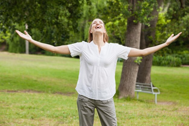 Femme aux bras tendus au parc