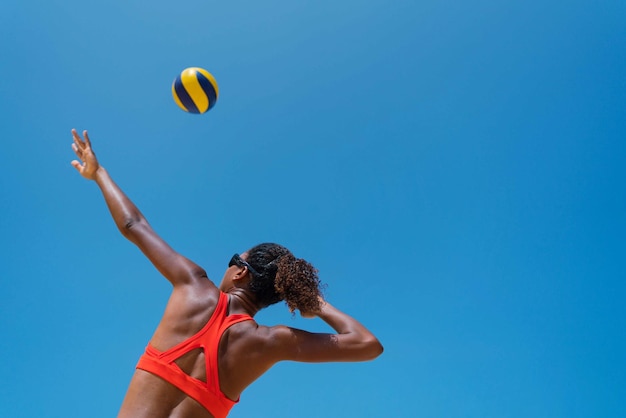 Photo une femme aux cheveux afro joue au volleyball de plage.