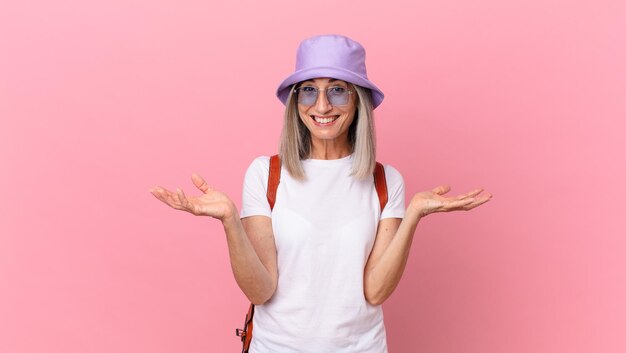 Femme aux cheveux blancs d'âge moyen étonnée, choquée et étonnée d'une incroyable surprise. notion d'été