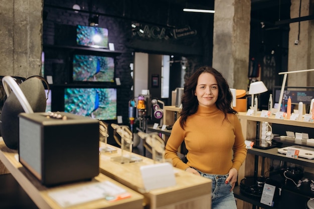 Femme aux cheveux bouclés dans un magasin d'électronique