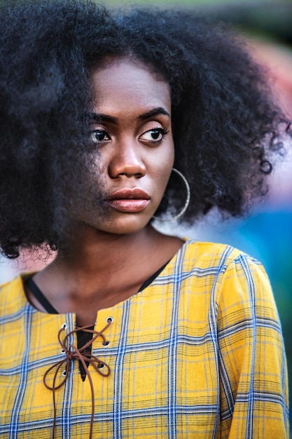 Une femme aux cheveux bouclés qui détourne le regard.