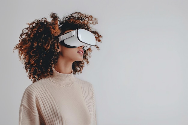 Une femme aux cheveux bouclés regardant autour d'elle dans des lunettes de réalité virtuelle dans une pièce blanche