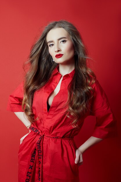 Femme aux cheveux bouclés robe rouge sur fond rouge