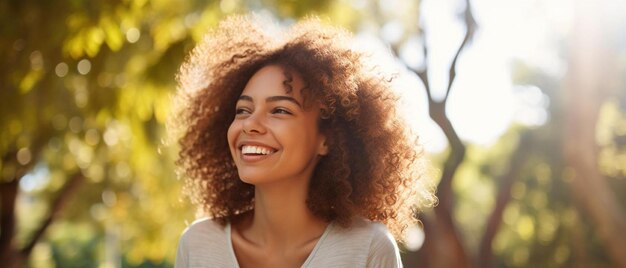 une femme aux cheveux bouclés souriant dans un parc