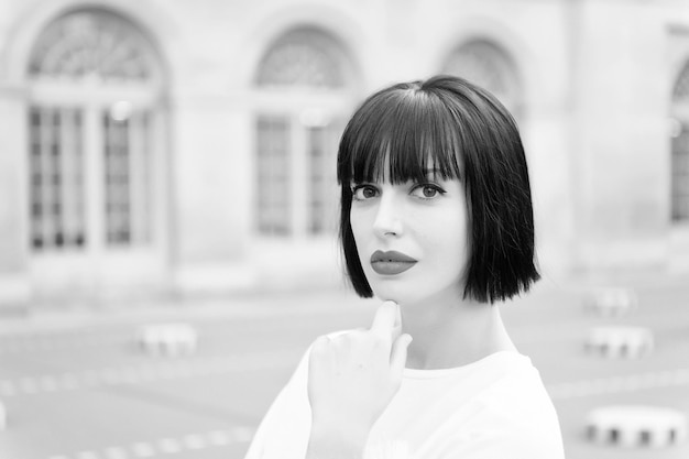 Femme aux cheveux bruns et aux lèvres rouges maquillage visage à Paris France