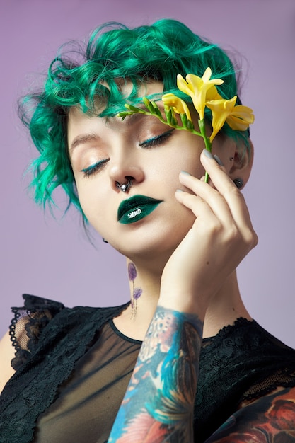 Femme aux cheveux créatifs et coloration verte créative, mèches de cheveux toxiques.