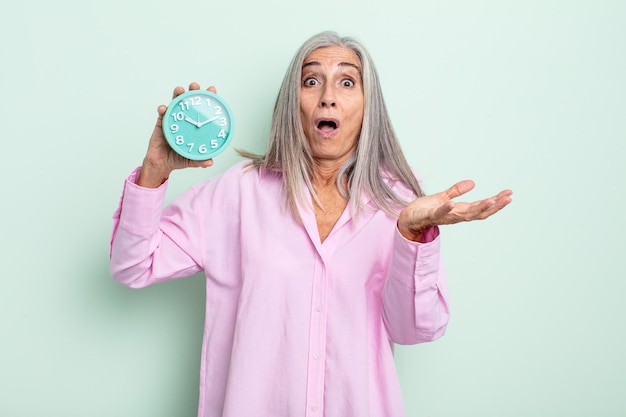 Femme aux cheveux gris d'âge moyen étonnée choquée et étonnée par un incroyable concept de réveil surprise