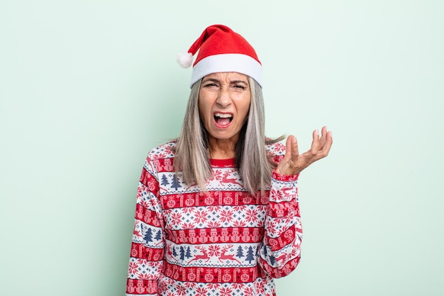 Femme aux cheveux gris d'âge moyen à la recherche de concept de noël agacé et frustré en colère