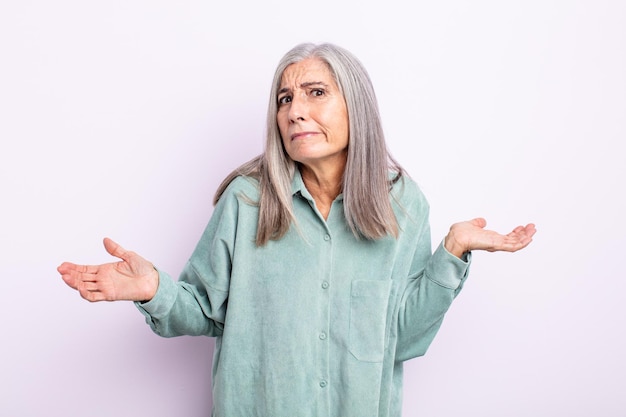 Femme aux cheveux gris d'âge moyen se sentant désemparée et confuse, n'ayant aucune idée, absolument perplexe avec un regard stupide ou stupide