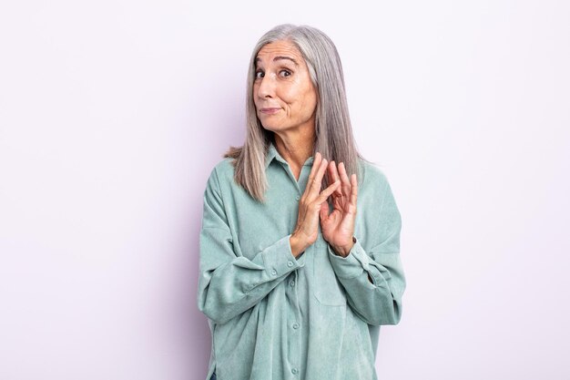 Femme aux cheveux gris d'âge moyen se sentant fière, espiègle et arrogante tout en préparant un plan diabolique ou en pensant à un tour