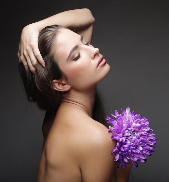 Femme aux cheveux longs tenant une grande fleur