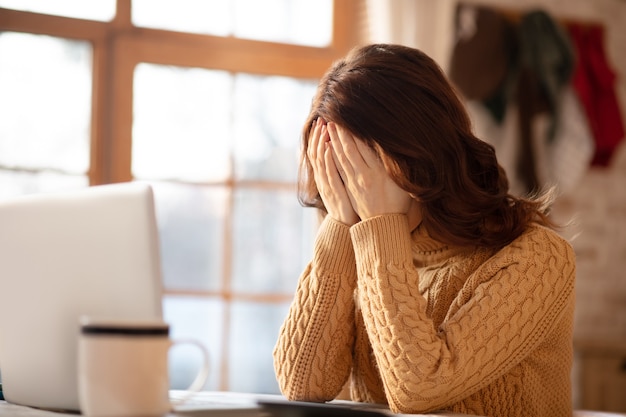 Femme aux cheveux longs tenant sa tête