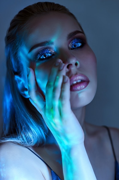 Femme aux cheveux mouillés et maquillage lumineux près de l&#39;eau