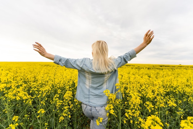 Femme aux fleurs jaunes. Portrait d'été d'une femme dans un champ de colza.