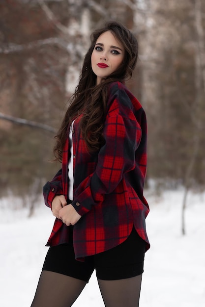 Femme aux lèvres rouges dans la forêt d'hiver