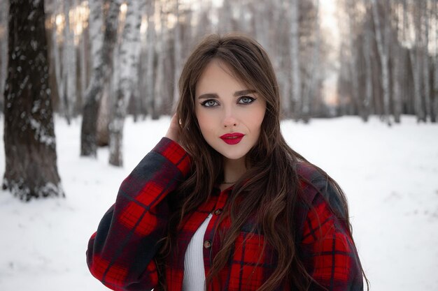 Femme aux lèvres rouges dans la forêt d'hiver