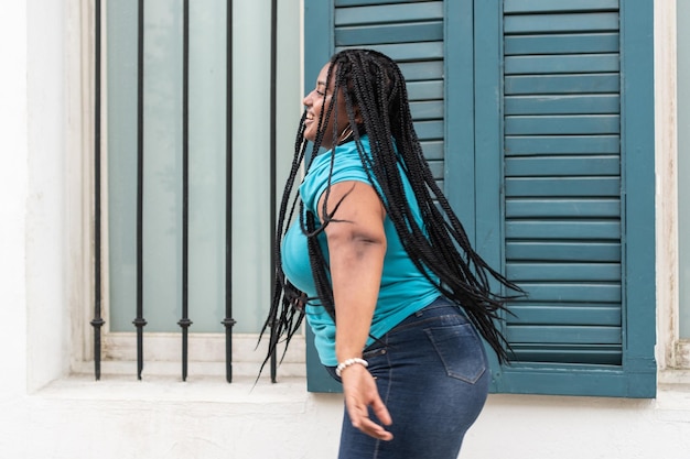 Femme aux longues tresses dansant dans la ville très heureuse