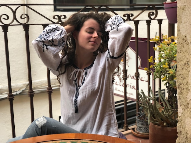 Photo une femme aux yeux fermés assise près des plantes.