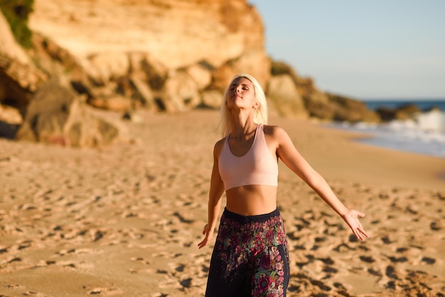 Une femme aux yeux fermés sur la plage.