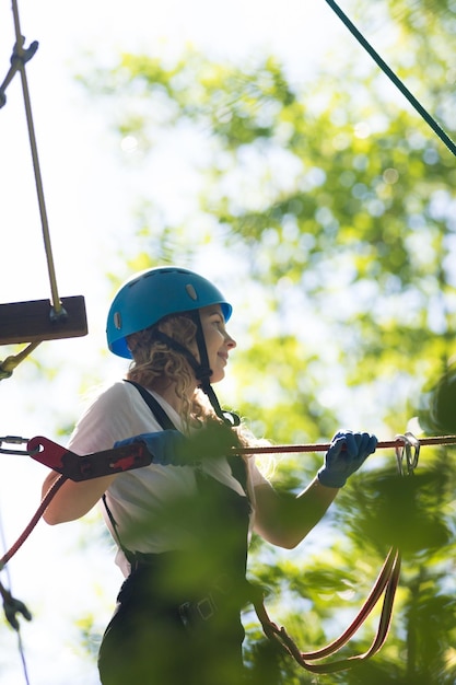 La femme d'aventure de corde marche sur le pont suspendu de corde