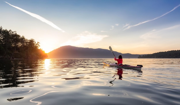 Femme aventureuse en kayak de mer pagayer dans l'océan pacifique