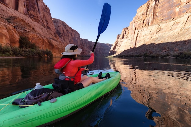 Femme aventureuse sur un kayak pagayant dans le fleuve colorado