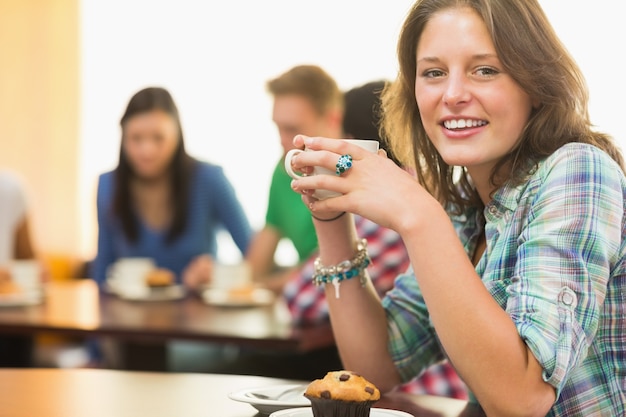 Femme ayant un café et un muffin au café