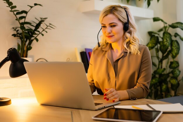 Femme ayant une conversation vidéo avec des collègues sur un ordinateur portable au bureau, gros plan