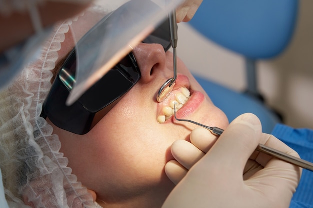 Photo femme ayant des dents vérifier au bureau de dentiste