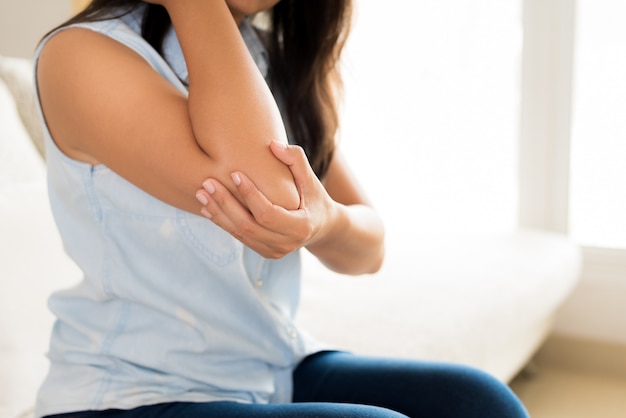 Photo femme ayant mal au coude blessé. concept de soins de santé.