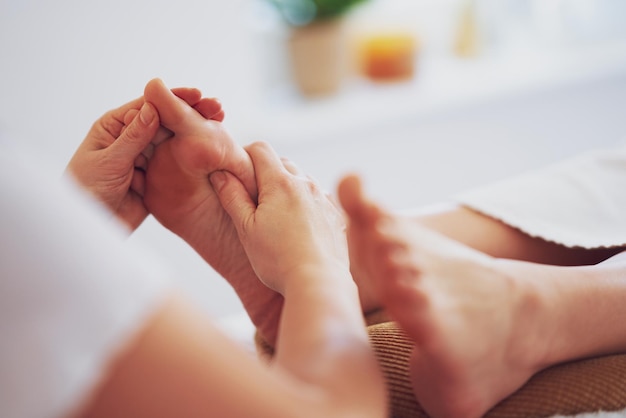 Femme ayant un massage de réflexologie plantaire au salon