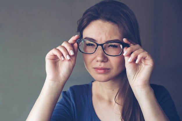 Une femme ayant des problèmes de vision voit mal à travers ses lunettes
