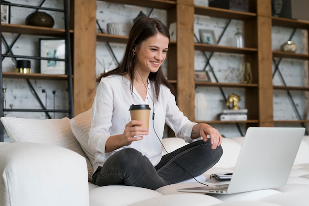 Femme ayant une réunion d'affaires en ligne sur son ordinateur portable